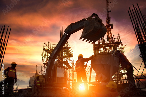 Cuadros en Lienzo Silhouette Teams of Business Engineers looking for blueprints in construction sites through blurry construction sites at sunset