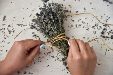 Girl hands hold bunch of dry lavender.