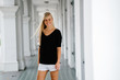 © Danon - An image of a pretty and young blonde woman standing in the corridor of an old colonial style building. She is an exchange student and enjoys wandering around her new campus.
