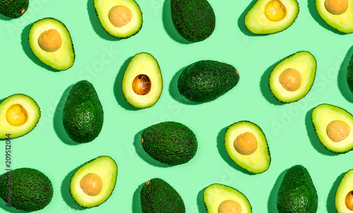 Cuadros en Lienzo Fresh avocado pattern on a green background flat lay