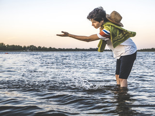 Wall Mural - young handsome boy makes water splashes in the sea water