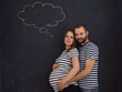 © .shock - pregnant couple posing against black chalk drawing board