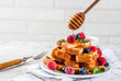 © ricka_kinamoto - Healthy summer breakfast, baked french toasted bread sticks with fresh berry and honey, morning light grey stone background copy space
