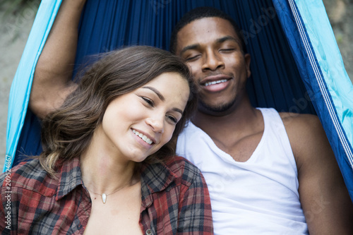 Foto Mixed race couple laying down in hammock