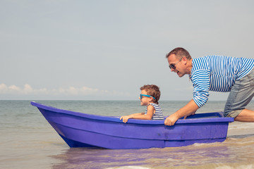 Father and son  playing on the beach at the day time.