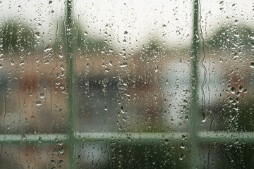 rain drops on a window with fence