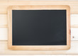 © Chinnapong - Blank black chalkboard frame with copyspace hanging on pine wood wall for announcement and restaurant menu