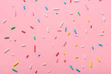 Colorful Sprinkles Over Pink Background, Decoration For Cake And Bakery