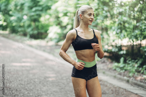 Mata magnetyczna Młoda kobieta działa. Piękna, dopasowana dziewczyna. Model fitness na świeżym powietrzu. Utrata masy ciała