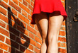 legs of a young woman in red dress closeup
