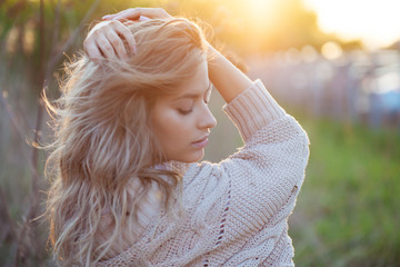 Cute charming girl in summer in the field. Young woman is happy and feels free outdoors