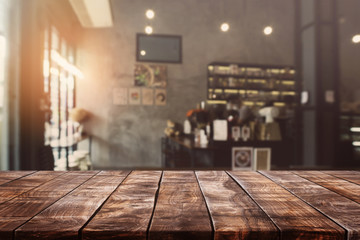 empty old wood table top and blurred bokeh cafe and coffee shop interior background with vintage fil