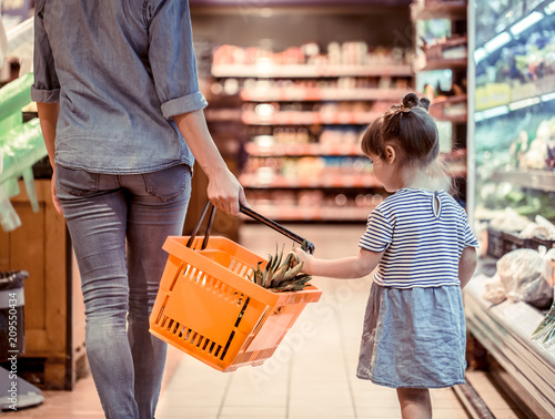 Fotomural Mom and daughter are shopping at the supermarket