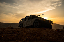 Military Patrol Car On Sunset Background. Army War Concept. Silhouette Of Armored Vehicle With Gun In Action. Decorated.