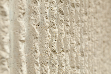 Surface of the wall with a decorative white plaster. Textured concrete wall with vertical lines and stripes as a texture or background. Repair, design concept.