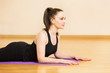 © Mayatnikstudio - Young woman is making yoga exercises on a mat at gym background.