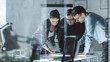 © Gorodenkoff - Three Design Engineers Have a Working Meeting about Project. Various Drafts, Components and Notebook laying on the Table.
