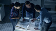 © Gorodenkoff - Late at Night Team of Design Engineers Work with Drafts and Documents on Illuminated Table.
