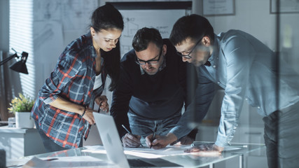 Team of Design Engineers Collectively Work on the Project. They Inspect Drafts, Documents and Have Discussion at the Big Table.