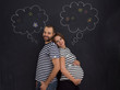 © .shock - pregnant couple posing against black chalk drawing board
