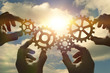 © gerasimov174 - Business concept idea. four hands of businessmen collect a puzzle from gears. Cooperation, teamwork, strategy, creativity, innovation.
