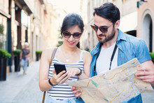 Young Happy Tourist Couple Visiting Travel Destination City With Smartphone App