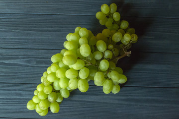 Ripe grapes on a dark blue wooden background.