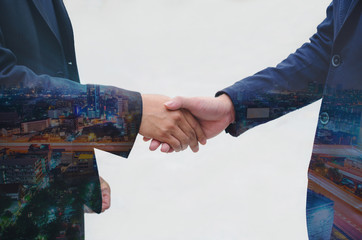 double exposure of businessman shaking hands with night cityscape for complete business deal together successful. teamwork concept. partnership and dealership concept and property real estate.