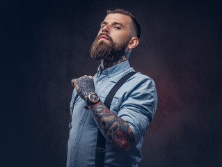 Wall Mural - Portrait of a handsome old-fashioned hipster in a blue shirt and suspenders.