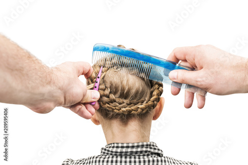 Juliste Male hands make a hairstyle for a little girl with a comb and a hair clip, isola