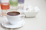 Fototapeta Dinusie - Turkish coffee with milk cream chocolate pistachio Turkish delight and cup of water