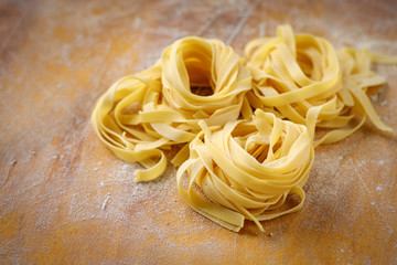 Wall Mural - fresh tagliatelle pasta on a wooden table with flour