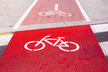 Signs and bike lane markings painted on the asphalt of the streets of an urban city