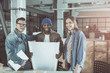 © Yakobchuk Olena - We did it. Portrait of happy young pleasant colleagues are showing white poster while standing together in office and looking at camera with smile. Teamwork and cooperation concept