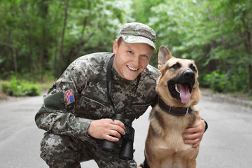 Wall Mural - Man in military uniform with German shepherd dog, outdoors