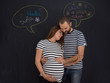 © .shock - pregnant couple posing against black chalk drawing board