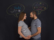 © .shock - pregnant couple posing against black chalk drawing board