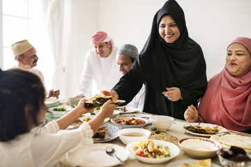 Muslim woman sharing food at Ramadan feast