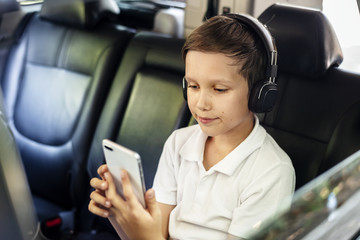 Wall Mural - Boy playing on a smartphone in the car