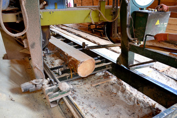 Sawmill. Process of machining logs in equipment sawmill machine saw saws the tree trunk on the plank boards. Wood sawdust work sawing timber wood wooden woodworking