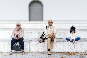 Wall Mural - Muslim family sitting together outdoors