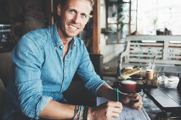 Wall Mural - Portrait of cheerful entrepreneur working on his project at street cafe