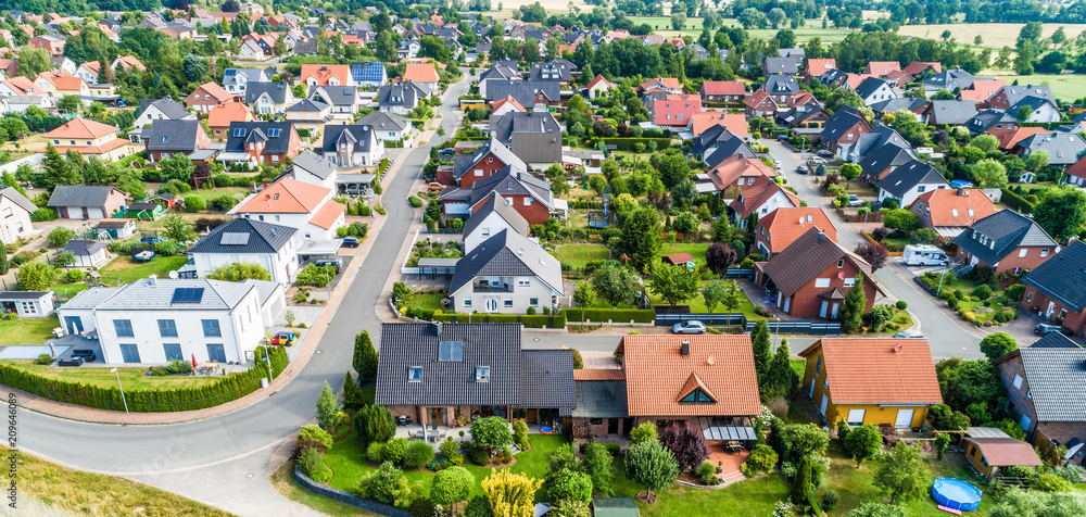 Typical German new housing development in the flat countryside of northern Germany between a forest and fields and meadows - obrazy, fototapety, plakaty 