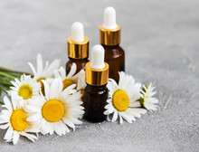 Bottles With Essential Oils With Chamomile Flowers