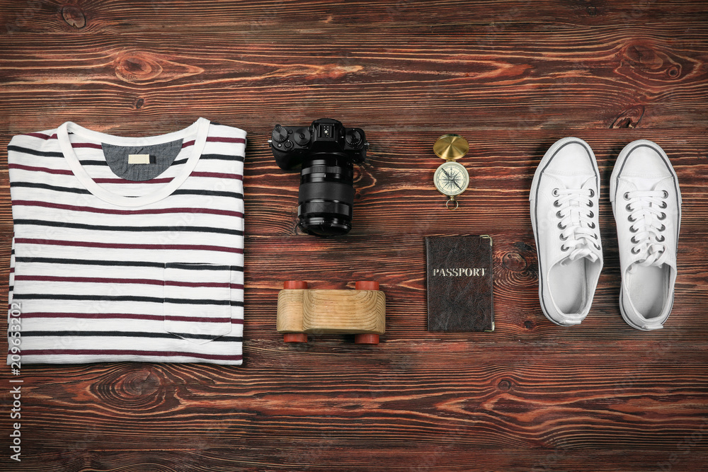 Composition with tourist's stuff on wooden background, top view