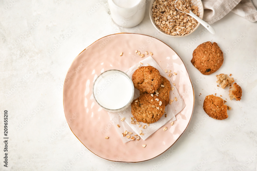 Composition with delicious oatmeal cookies and milk on light background, top view