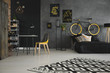 Patterned carpet in teenager's room interior with yellow chair at desk and bike above bed. Real photo