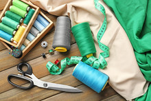 Composition With Color Threads And Sewing Accessories On Wooden Background