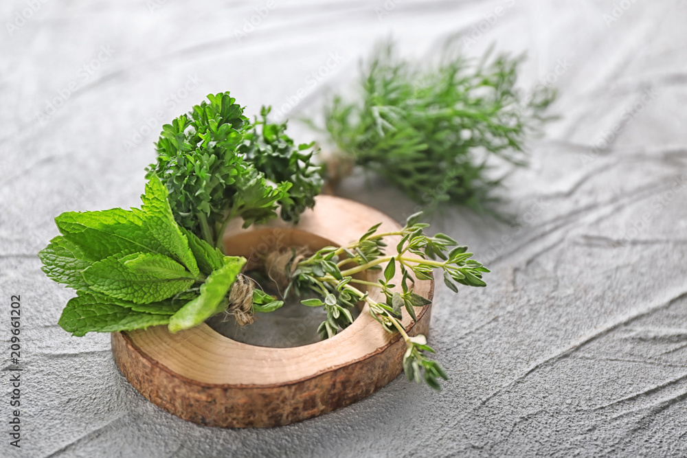 Different fresh herbs on grey background