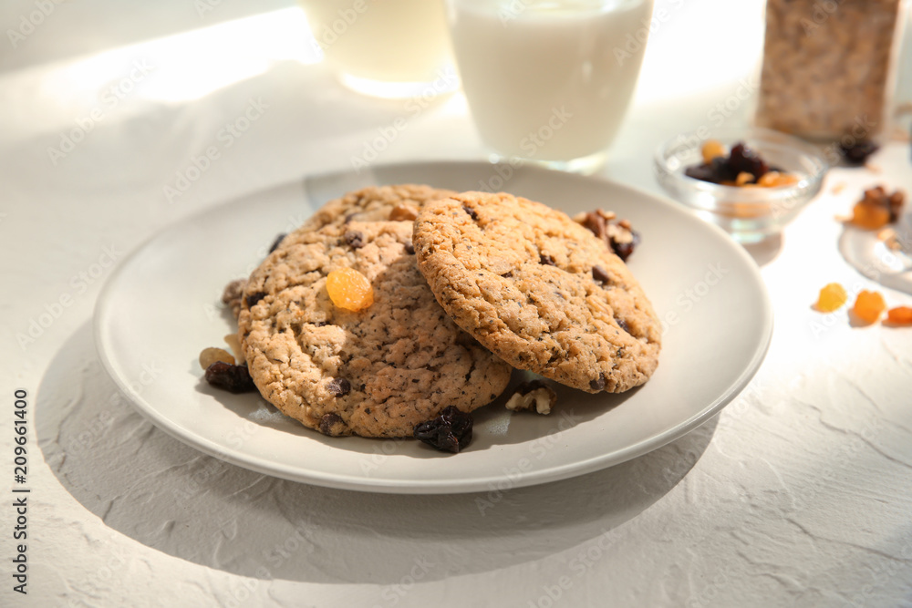 Plate with delicious oatmeal cookies on white table